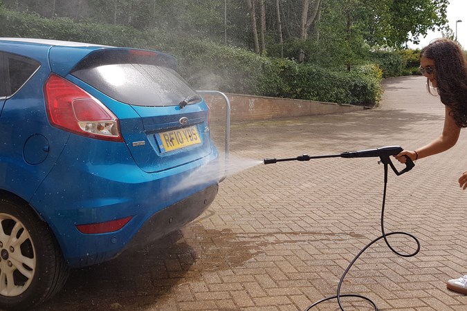 The first stage of a cleaning a car is to hose off the loose dirt.