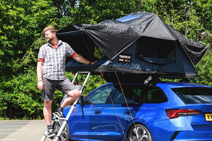Adam Binnie next to a Skoda Octavia VRS with roof tent