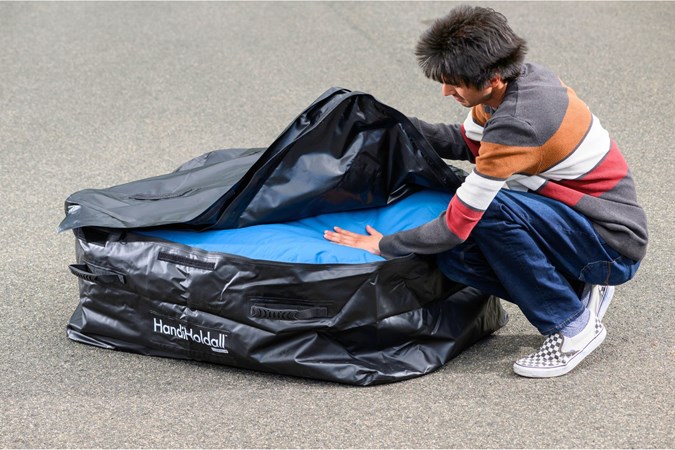 Aaron Hussain packing a HandiWorld roof bag