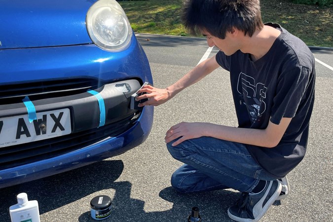 Aaron Hussain applying black trim restorer to a Citroen C1's bumper