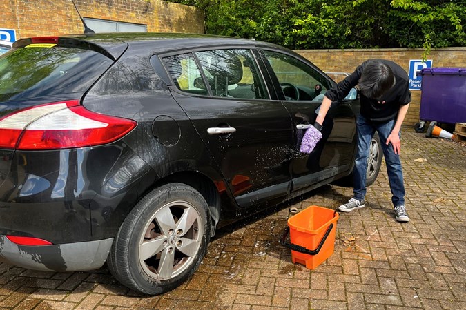 Aaron Hussain cleans a black car using ValetPRO shampoo