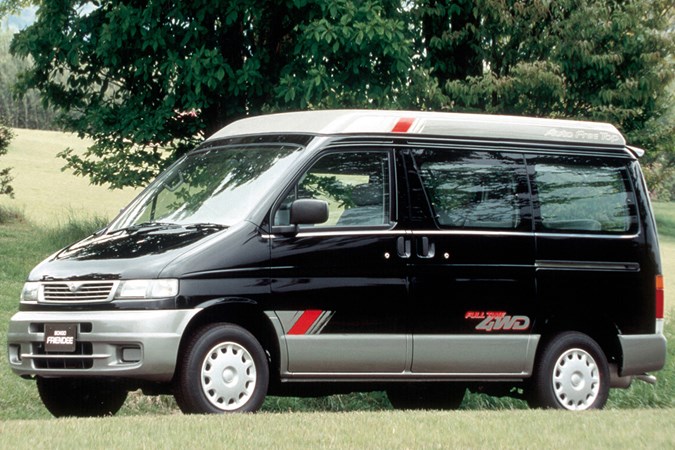 Black Mazda Bongo with grey bumpers and pop top and red accents, shot from front.