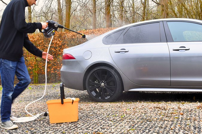 Aaron Hussain cleaning a Jaguar with a pressure washer