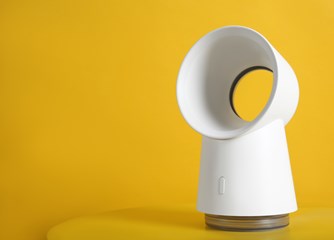 A white bladeless fan on a yellow background