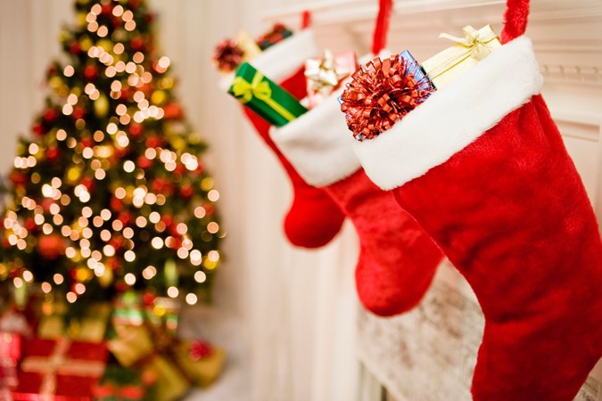 A trio of stockings next to a Christmas tree