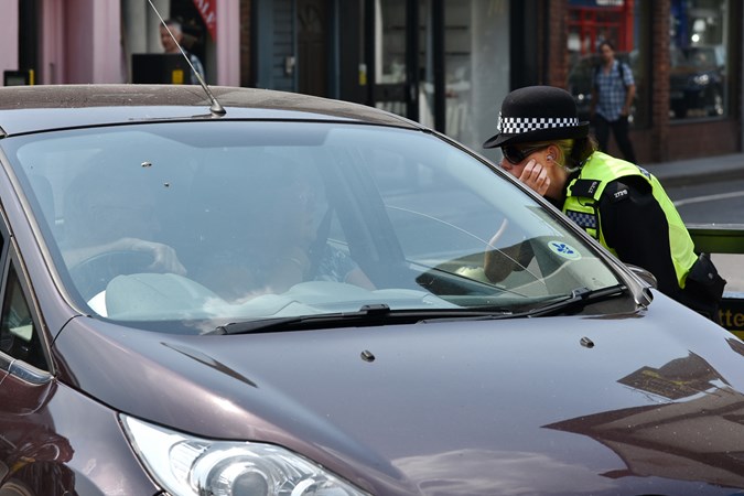 Cost of UK speeding ticket - police officer speaking to motorist