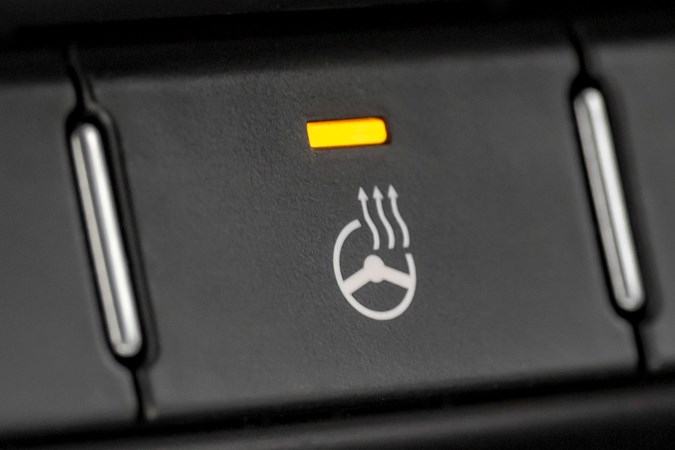 Heated steering wheel button close up, orange light on