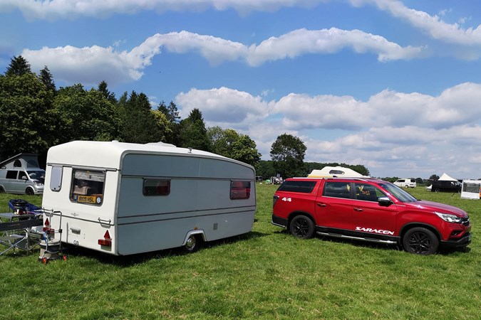 A 2019 Ssangyong Musso with a caravan, in a field, photograph by Luke Neal