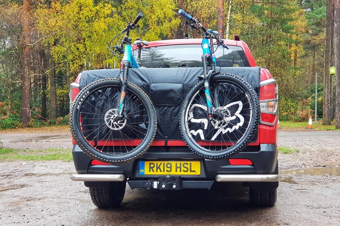 Two bikes resting on the tailgate of a Ssangyong Musso pickup