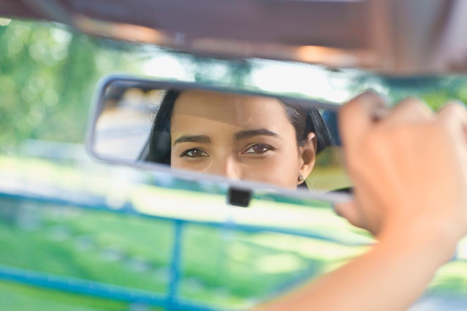 Woman looking in a rearview mirror - Mirror dashcam