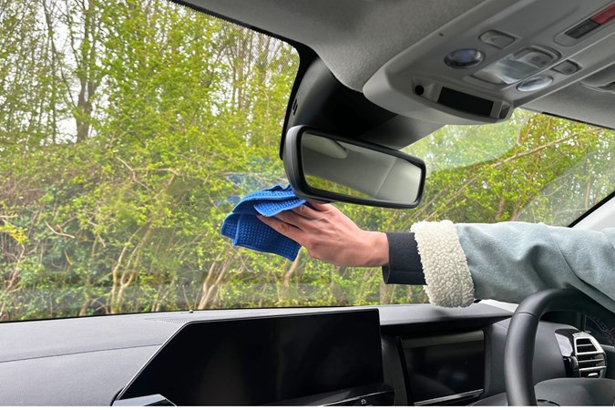 Aaron Hussain wipes a car windscreen using a glass wipe.