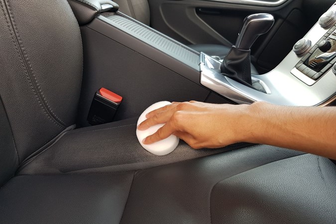 Aaron Hussain testing the CarPlan leather cleaner on a Volvo seat