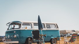 VW camper next to some camping chairs