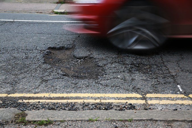 A car about to pass over a pothole.