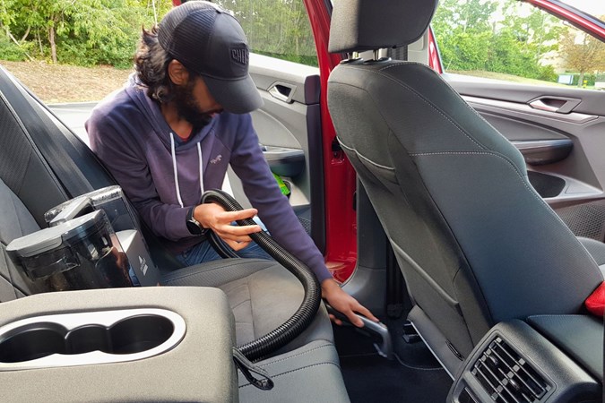 Naveed Hussain testing the Bissell SpotClean on a VW Golf's carpet