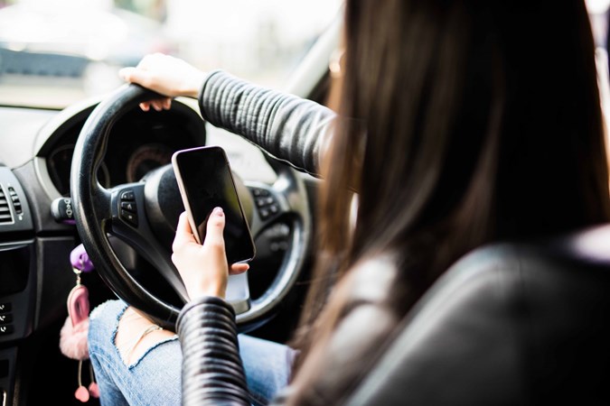 It's now illegal to have your phone in your hand or even touch it while driving.