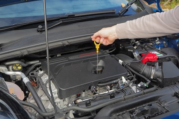 Checking oil dipstick on a Ford motor