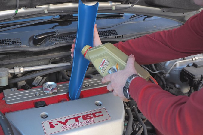 Topping up engine oil with a funnel