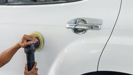 Polishing pad being used on a white car