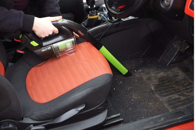 Vacuuming a car with a cordless vacuum cleaner 