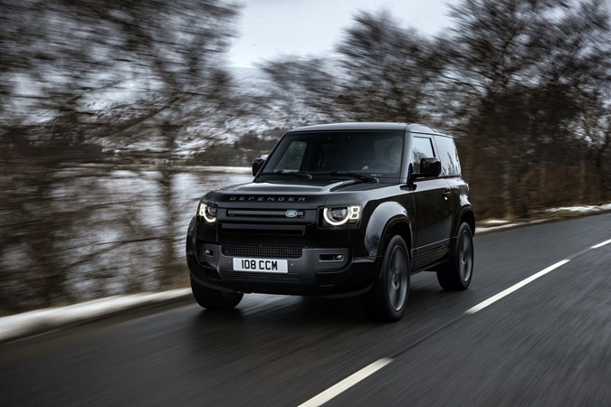 A black Land Rover Defender 90 driving on wintery roads. Our best small luxury car for adventure. 