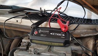 CTEK MXS 5.0 smart battery charger next to battery
