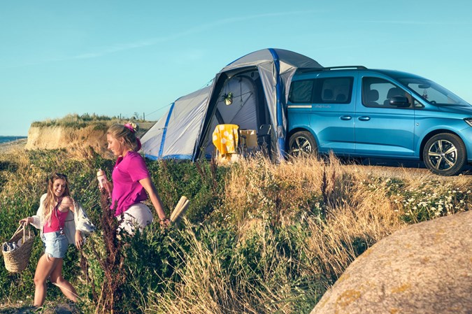 VW Caddy California camper van - in field with tent and happy campers