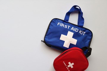 Two first aid kits on a neutral background