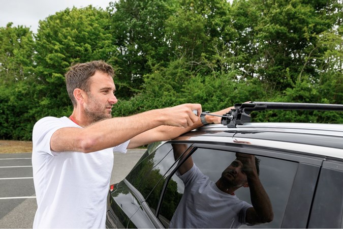 Oli Reed installing roof bars onto vehicle