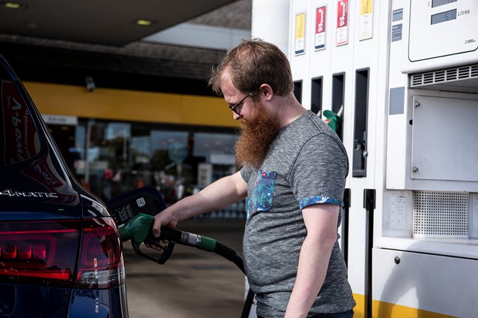 Test car editor Alan Taylor Jones stands in a Shell fuel station filling up a Mercedes SUV