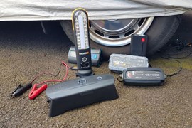 Car battery chargers lined up next to wheel