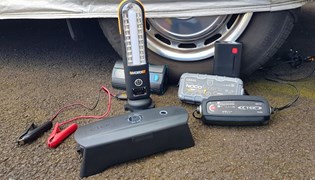 Car battery chargers lined up next to wheel
