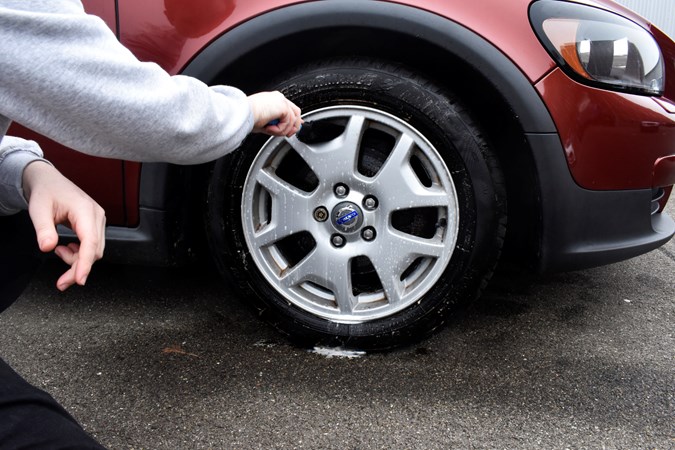 Cleaning a car's alloy wheel with a brush