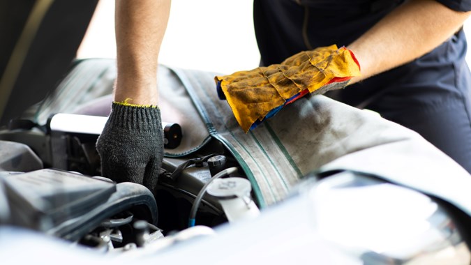 Garage gloves being used during car maintenance