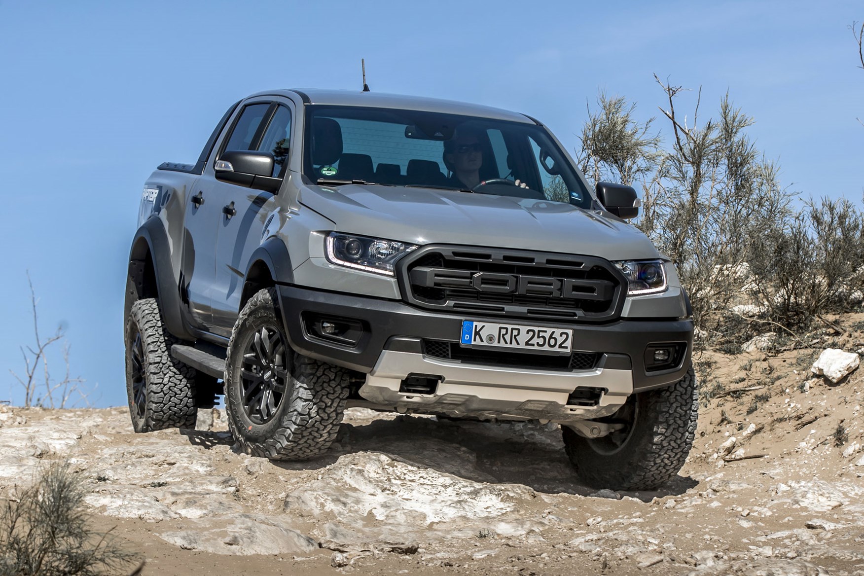 Ford Ranger Raptor - front view, Conquer Grey, parked on rocks showing off axle articulation