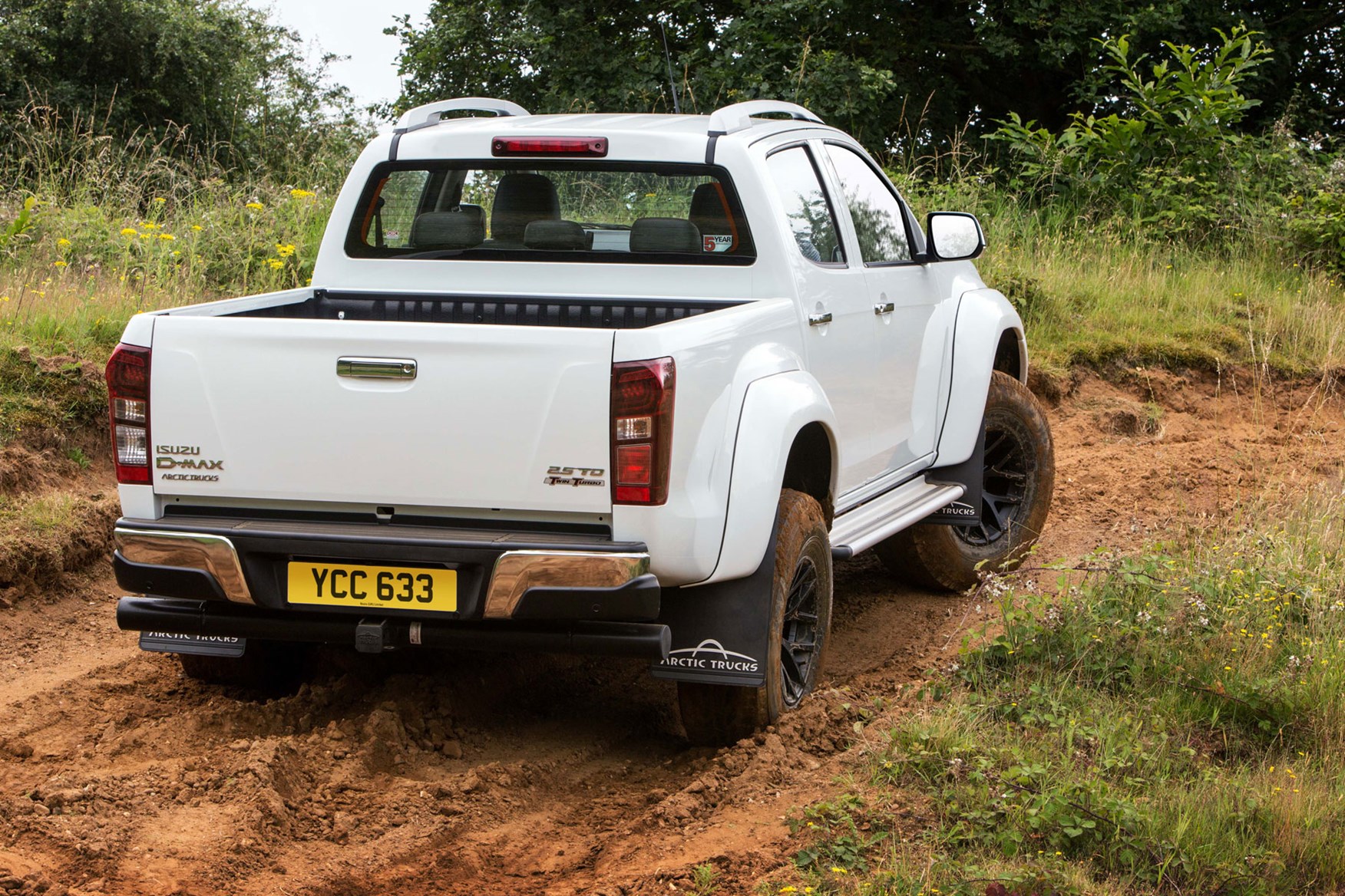 Isuzu D-Max AT35 2.5 review - rear view, driving up muddy hill, white