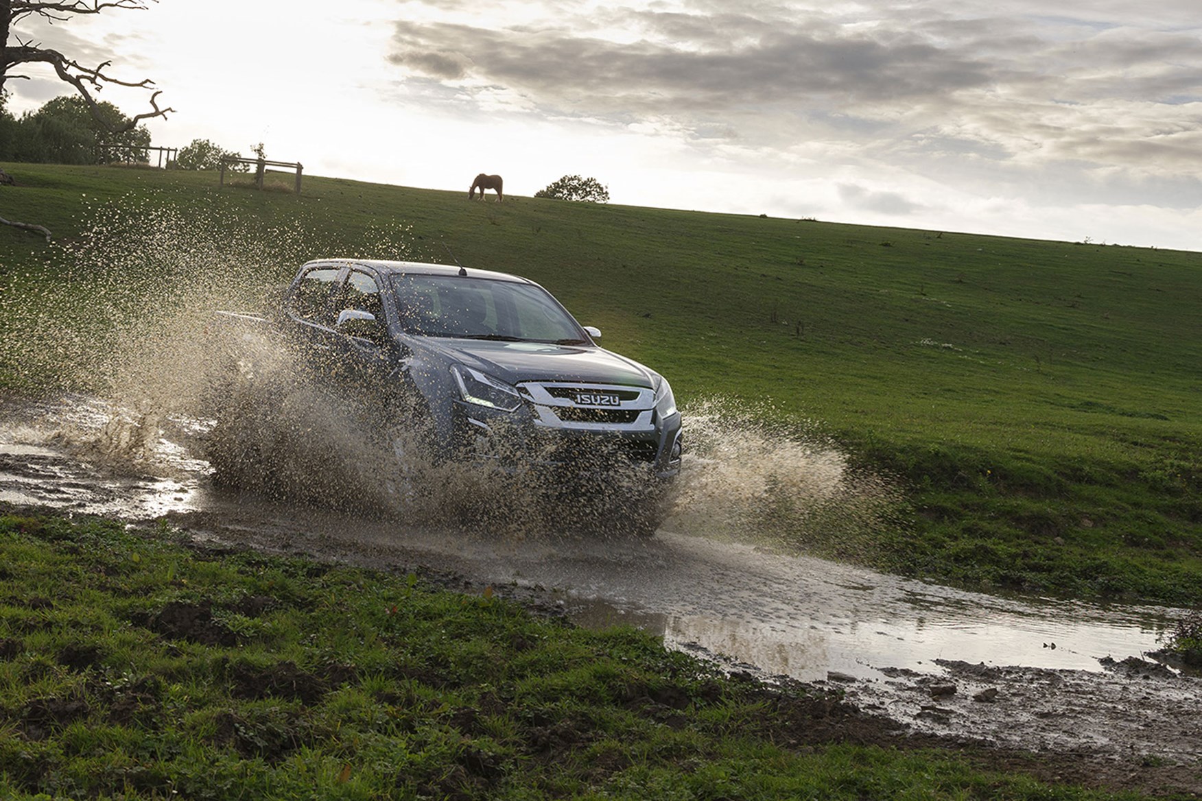 Isuzu D-Max Yukon review - splashing through water in field, grey