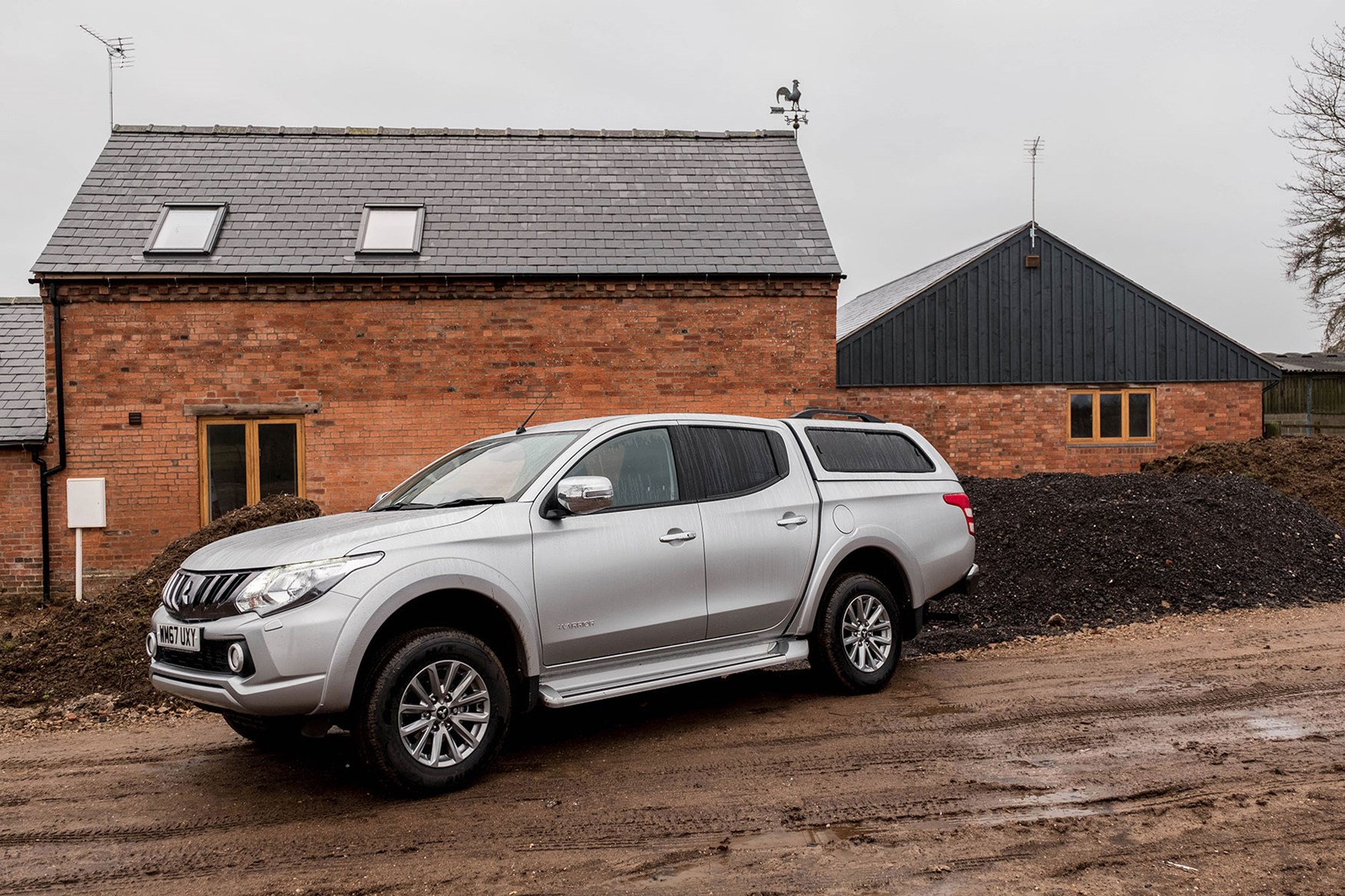 Mistubishi L200 Warrior 2018 review - side view, silver, rain, parked in front of farm building