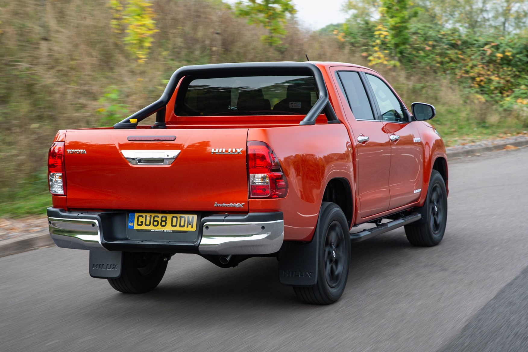 Toyota Hilux review - rear view, driving, Invincible X, orange