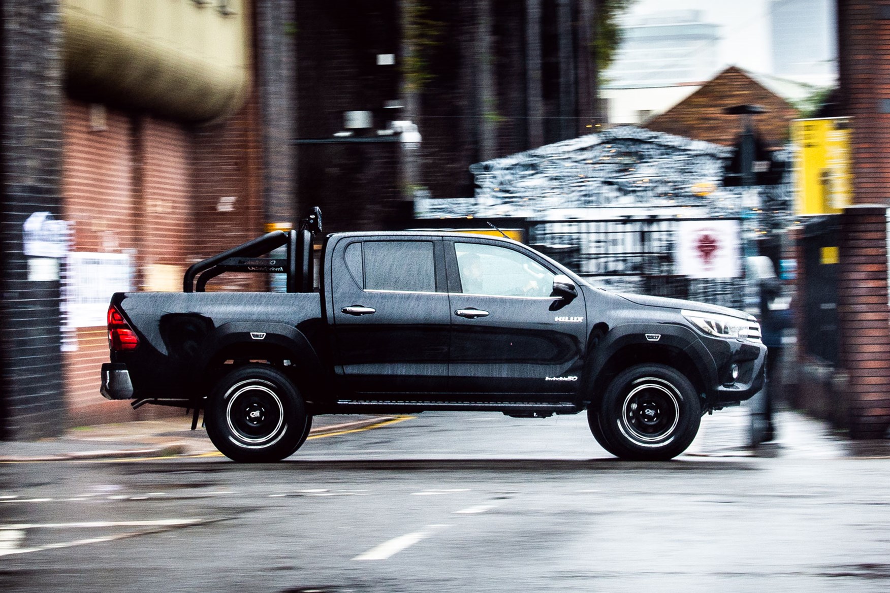 Toyota Hilux Invincible 50 review - driving, side view, in the rain