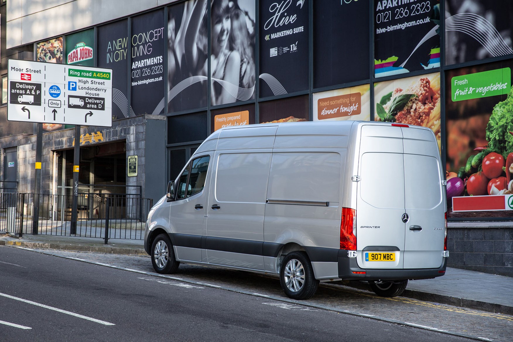 Mercedes Sprinter (2018-on), rear view, silver, UK, parked at junction with traffic signs, safety