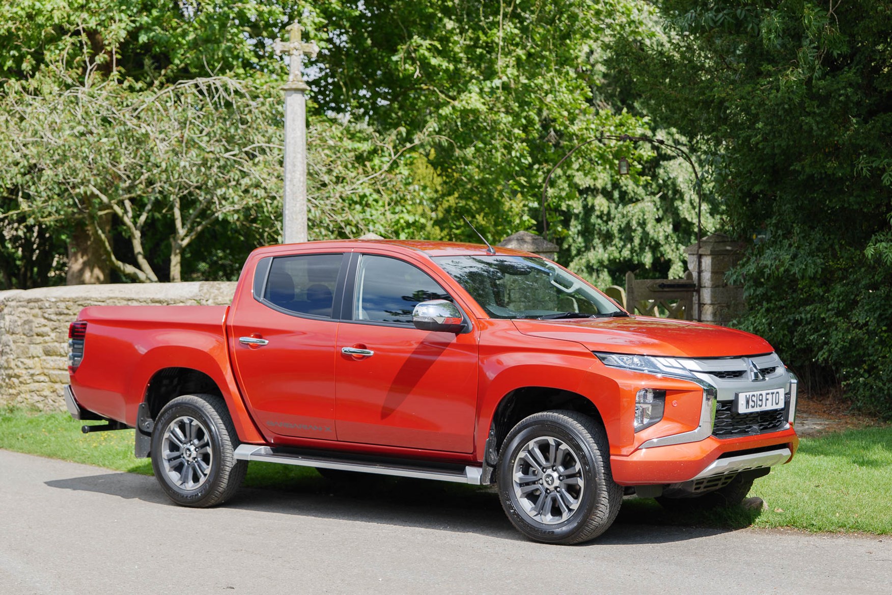 2019 Mitsubishi L200 Series 6, Sunflare Orange Barbarian X in a small village