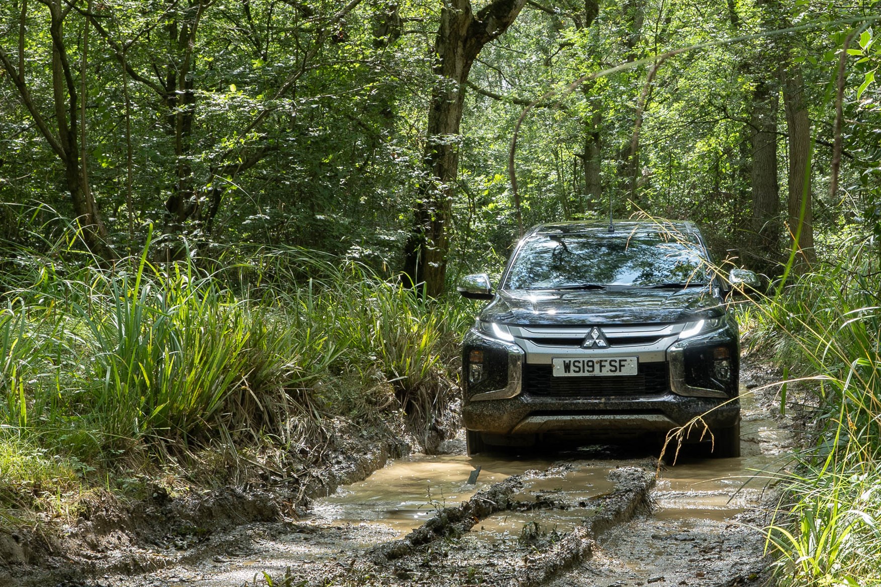 2019 Mitsubishi L200 4x4, Jet Black, on muddy forest track