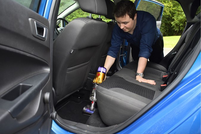 Ryan Gilmore tests out the Hair Screw tool on the Dyson V12 in a car, his favourite cordless vacuum cleaner