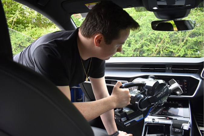 Ryan Gilmore vacuums the dash board of a car with the Vax Blade 4