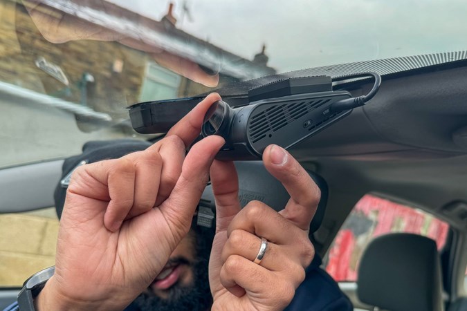 Image of a man putting a dash cam in position