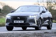 Image of a DS 4, in grey, driving round a right-hand corner, viewed from the car's front left corner