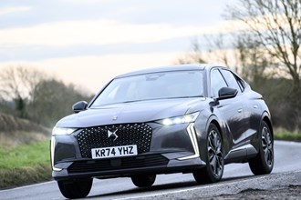 Image of a DS 4, in grey, driving round a right-hand corner, viewed from the car's front left corner