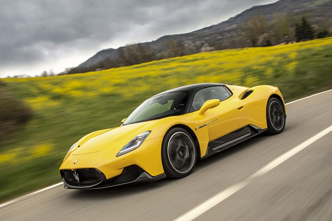 Maserati MC20 (2025) review: side view driving, yellow paint, low angle, graffiti