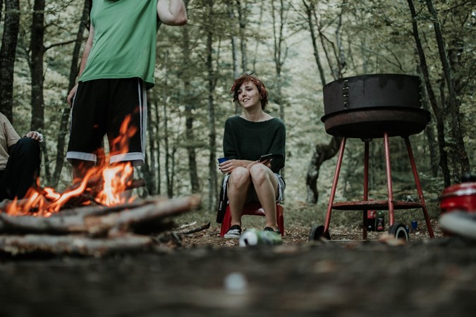 Woman sat around a campfire 